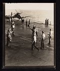 Shipboard Life. Men playing game with ball on flight deck in front of a plane